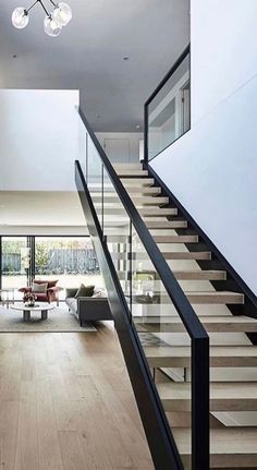 an open floor plan with stairs leading up to the upper level and glass railings on both sides