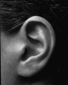 a black and white photo of a person's ear