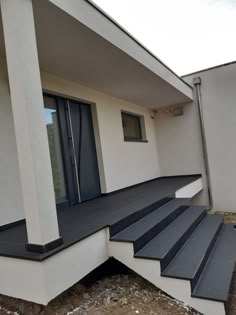 a house with black and white steps leading to the front door, windows and doors