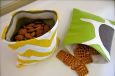 two bags filled with nuts sitting on top of a white table next to each other