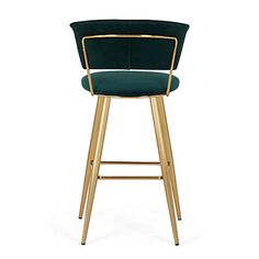 a green velvet bar stool with gold frame and footrests on an isolated white background