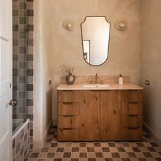 a bathroom with a sink, mirror and tiled floor