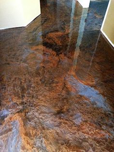 the floor is shiny and brown with some stains on it's surface in this room