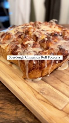 a cinnamon roll sitting on top of a wooden cutting board