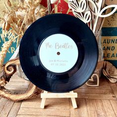 the beatles record is on a stand next to some flowers and other decorative items in front of a wall