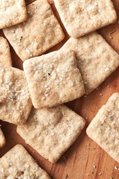 some crackers are sitting on a wooden cutting board and ready to be cut into bite sized pieces