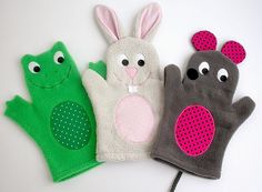 three mittens with different designs on them sitting next to each other, one in the shape of a rabbit and one in the shape of a frog