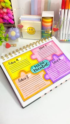 a happy new year's planner with markers, pens and pencils next to it