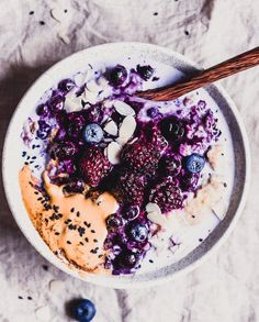 a bowl of oatmeal with blueberries, almonds and yogurt