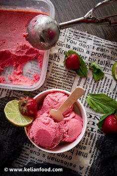 two bowls of ice cream with strawberries and limes on the table next to each other