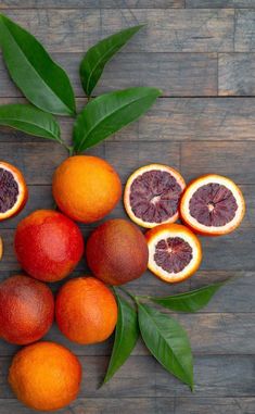 oranges and grapefruits arranged in the shape of a star on a wooden surface