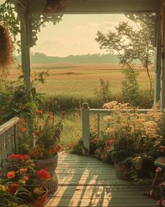 a porch covered in lots of flowers next to a lush green field with tall grass