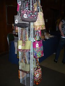 several purses are stacked on top of each other in a rack at an event