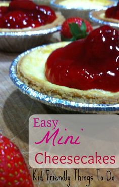 homemade mini cheesecakes with strawberry topping in pie tins on a wooden table