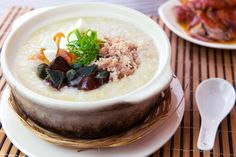 there is a bowl of soup with meat and vegetables on the plate next to it