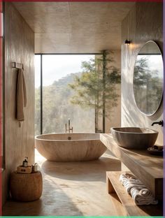 a bathroom with a large bathtub next to two sinks and a round mirror on the wall