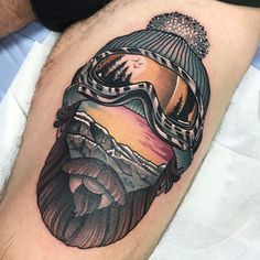 a man's thigh with a mountain and ski goggles tattoo design on it