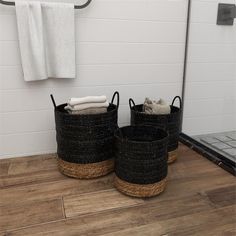 two black baskets sitting on top of a wooden floor