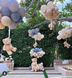 balloons and teddy bears are hanging from the ceiling in front of a backyard party setup