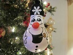 a snowman ornament hanging from a christmas tree