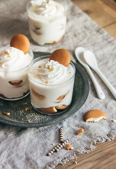 two desserts are sitting on a plate with spoons