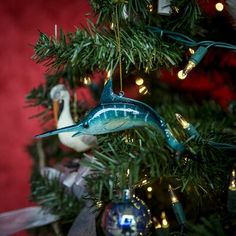 an ornament hanging from a christmas tree in the shape of a bird on a branch