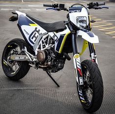 a white and blue dirt bike parked in a parking lot