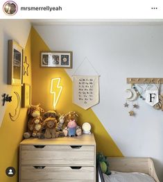 a child's bedroom decorated in yellow and white with teddy bears on the dresser