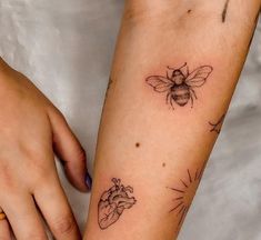 a woman's arm with two tattoos on it and a bee next to her