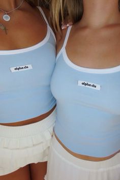 two women in blue tops and white skirts