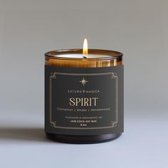 a candle that is sitting on top of a table in front of a gray background