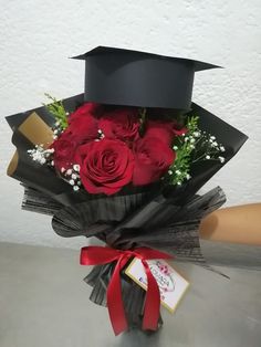 a bouquet of red roses in a graduation cap