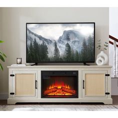 a flat screen tv sitting on top of a white entertainment center next to a fire place