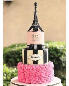 a pink and black cake with the eiffel tower in the top tiers