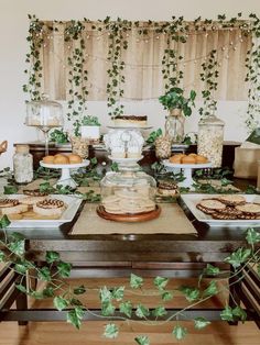 a table topped with lots of food covered in greenery