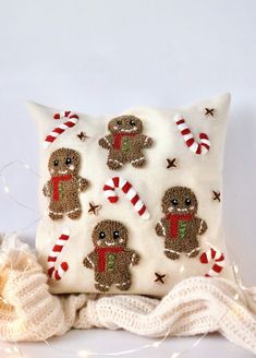 a white pillow with gingerbreads and candy canes on it