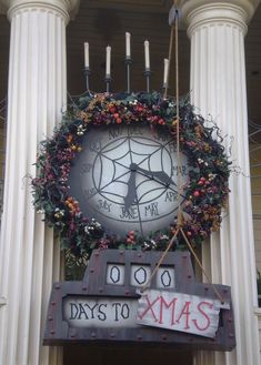 a large clock on the side of a building decorated with christmas wreaths and candles