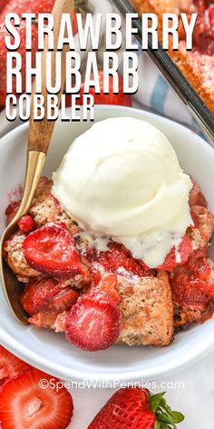 strawberry rhubarb cobbler in a white bowl with strawberries and ice cream