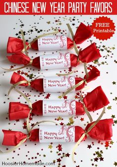 four new year's crackers wrapped in red and gold ribbon with stars around them