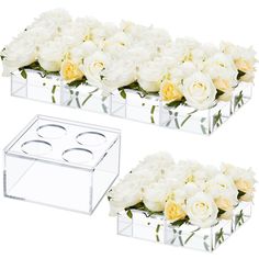 two clear boxes filled with white and yellow flowers next to each other on a white background