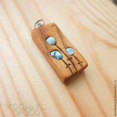 a wooden keychain with two blue eyes on it