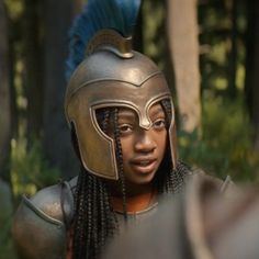 a close up of a person wearing a helmet with dreadlocks and braids