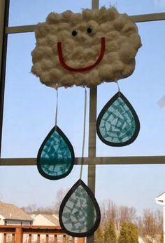 a window with some clouds and raindrops hanging from it