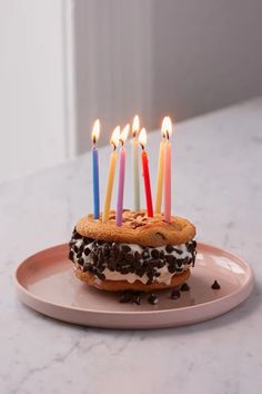 a birthday cake with lit candles sitting on a plate