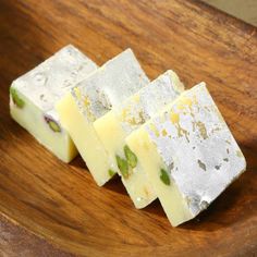 four pieces of cheese sitting on top of a wooden table