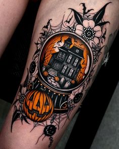 a halloween themed leg with a house and pumpkins in the center, surrounded by flowers