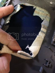 someone is peeling the fabric off of an old piece of cloth with their thumbnails