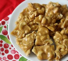 a white plate topped with pieces of food covered in peanut brittleer topping on top of a red and green table cloth