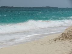 a person riding a surfboard on top of a sandy beach next to the ocean