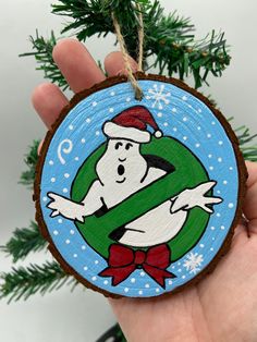 a hand holding a christmas ornament with a cartoon character on it